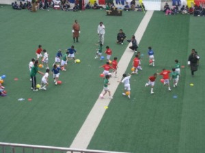 写真は「スポーツの日」にサッカーボールに見立てた風船を蹴る子供たち