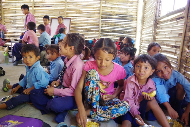 笑顔で給食を食べるコカナ村の子供たち