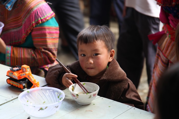 バックハーの食堂で麺を食べる少年