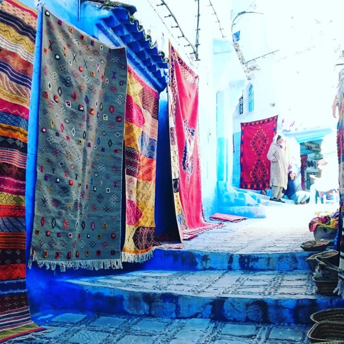 シャウエンの青い街並み。通りの絨毯もおしゃれに映ります。（モロッコ）
