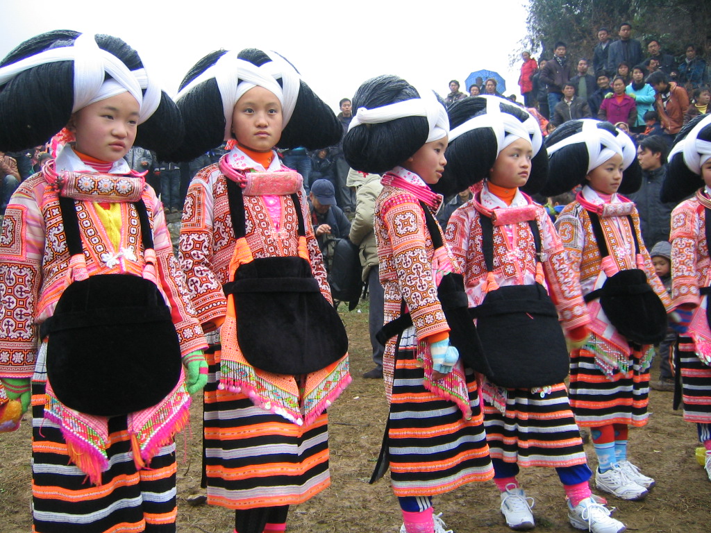 大きな角のような髪型と鮮やかな民族衣装の少女たち