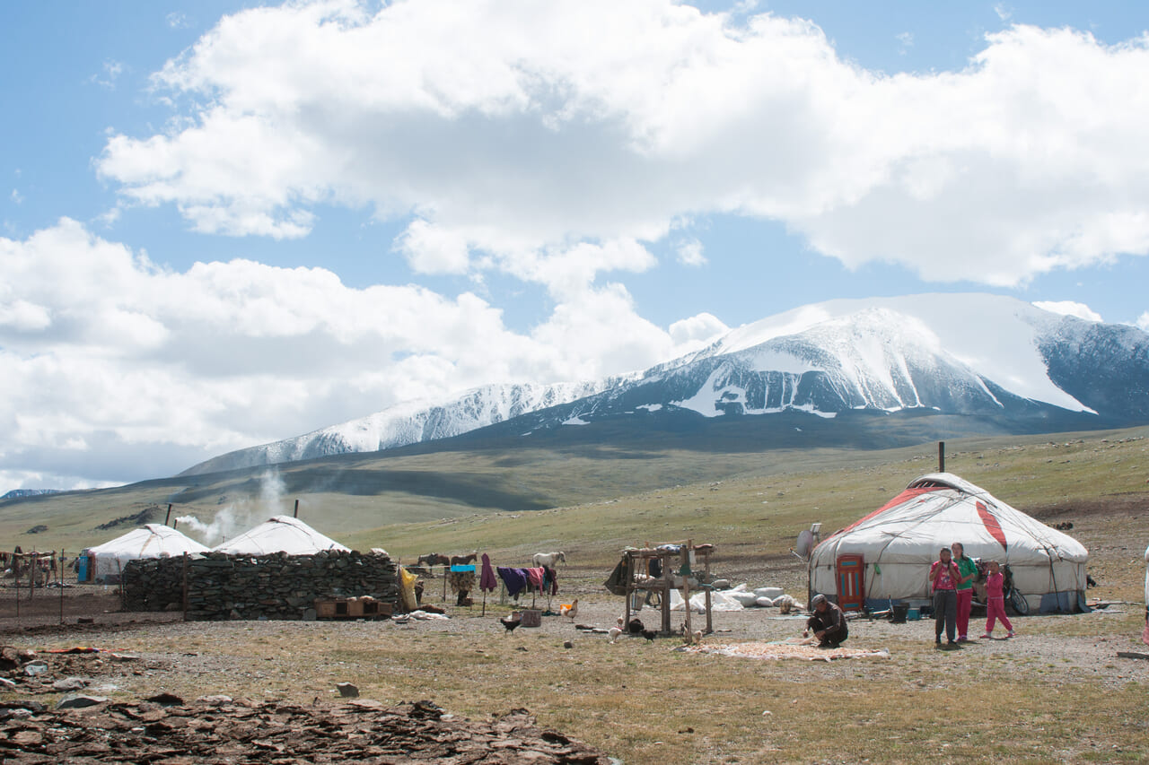 写真12　夏営地の様子。宿営地の後方には万年雪を被った山がそびえたつ。
