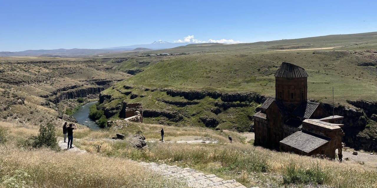 見えている川がトルコとアルメニアの国境を流れる川。遠方にはアルメニアの聖なる山アラガット山も望むこの地にアニ遺跡はあります