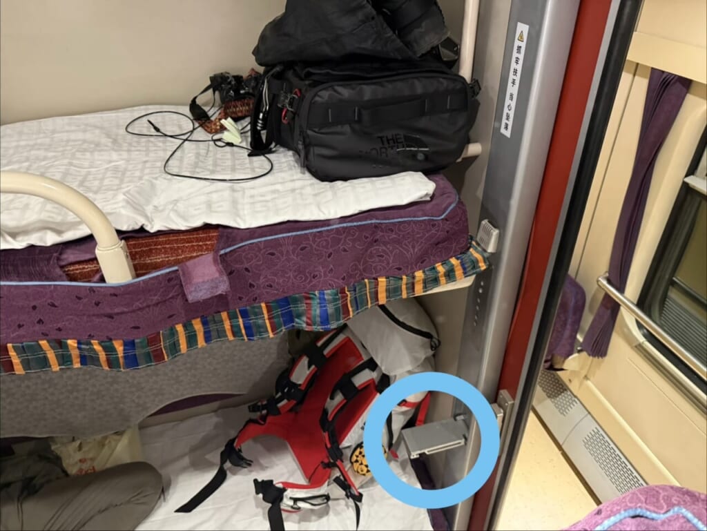 青色の丸印で囲っている銀色の台に足をかけて、二段ベッドへ移動します。